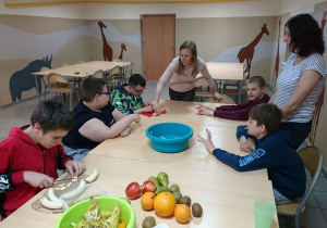 Grupy autystyczne przygotowują sałatkę owocową.